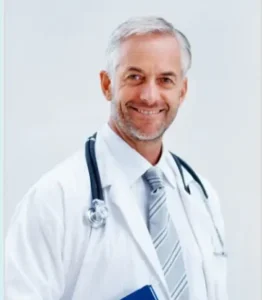 Médecin masculin avec blouse blanche et stéthoscope, souriant face à la caméra ; fond clinique neutre.