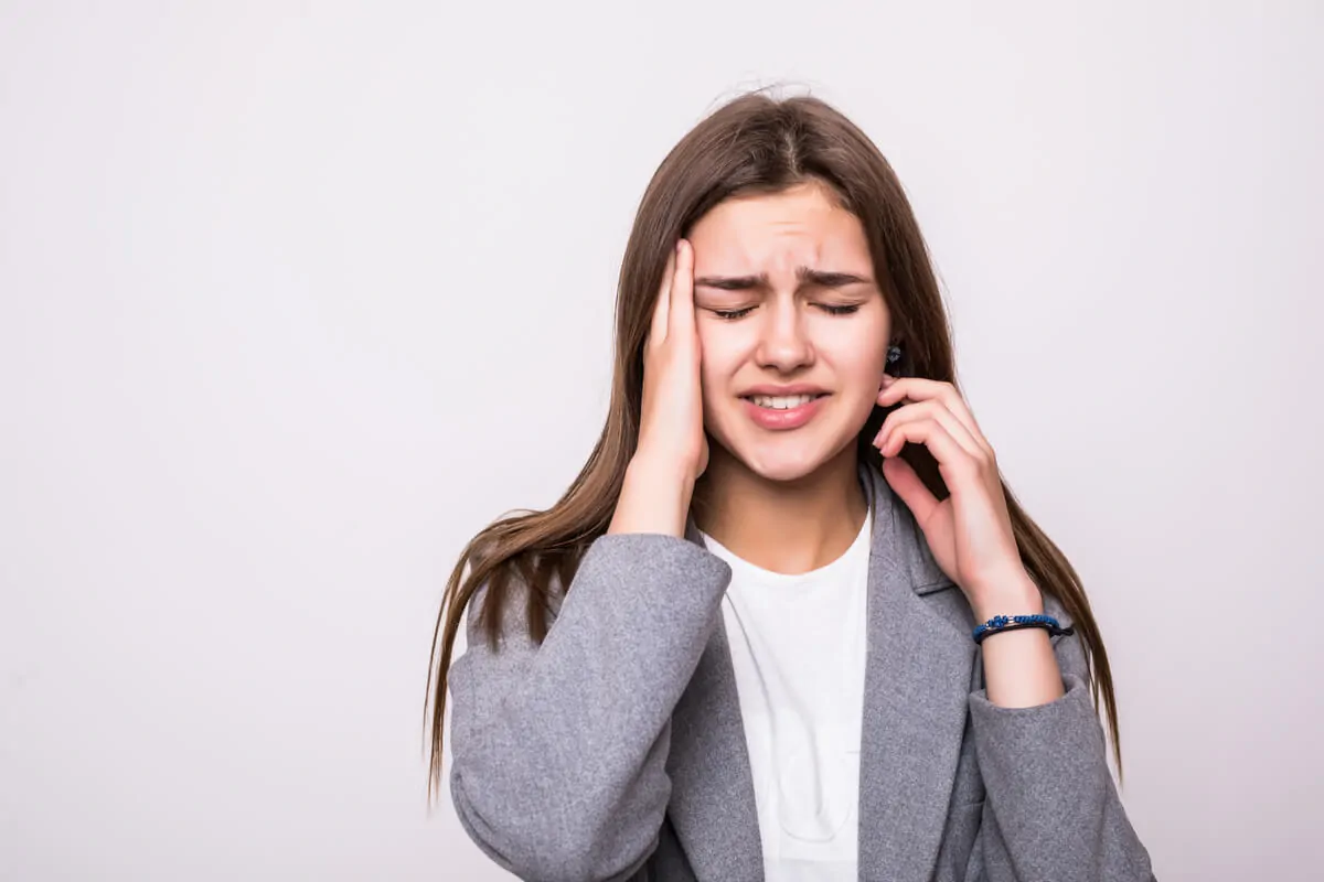 Le syndrome post-concussionnel et la réhabilitation neuropsychologique. Femme avec mal de tête.