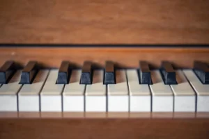 Touches de piano blanches et noires sur fond de bois, associées à un programme d'accessibilité musicale pour la réhabilitation.