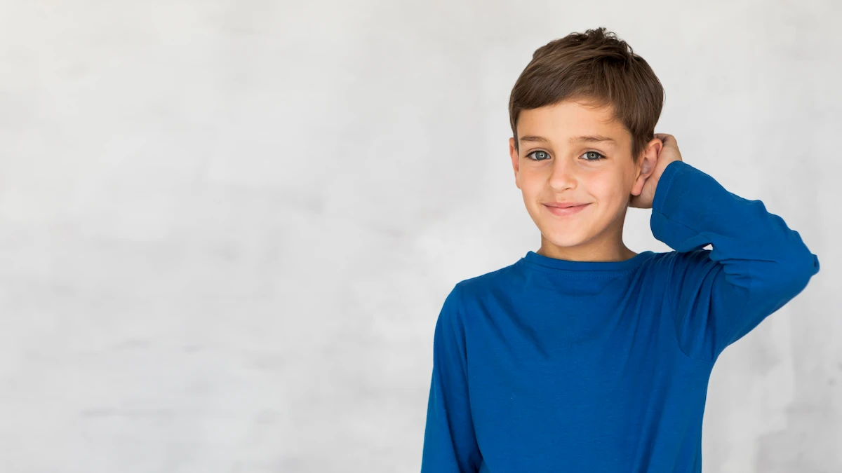 Enfant portant un T-shirt bleu souriant pendant des exercices cognitifs pour le TDAH, avec des outils interactifs.