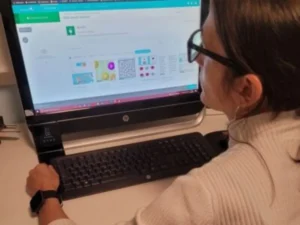 Professionista di neuropsicologia seduto di fronte a un computer in un ambiente clinico, che utilizza NeuronUP per stimolazione cognitiva (caso UNIR).