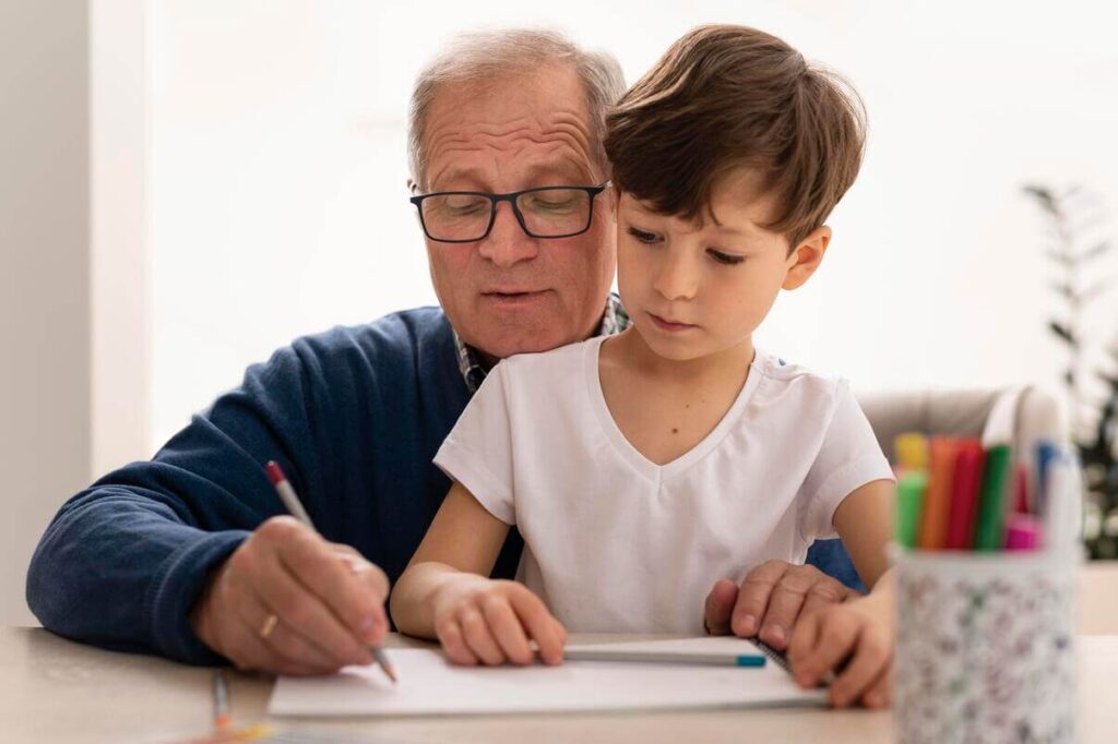 Suggerimenti e attività per migliorare l'attenzione. Nonno con il nipotino che svolge attività di stimolazione cognitiva