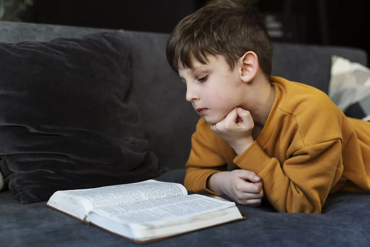 Illustrazione educativa di un bambino che legge un libro su un divano; tematica sulla coesistenza dell’autismo e della dislessia.