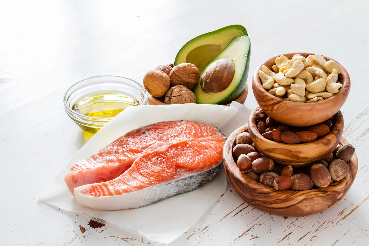 Composizione di alimenti sani: salmone, avocado, olio extravergine di oliva e frutta secca, per illustrare omega-3 e attenzione.