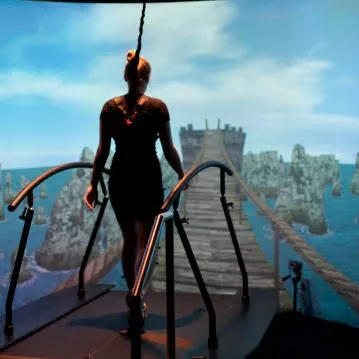 Человек стоит на платформе VR-симуляции и смотрит на экран с изображением пристани и моря; видны страховочная система и зал реабилитации.