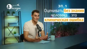 Мужчина сидит перед микрофоном на освещённой сцене во время NeuronUP Talks о нейродегенеративных деменциях.